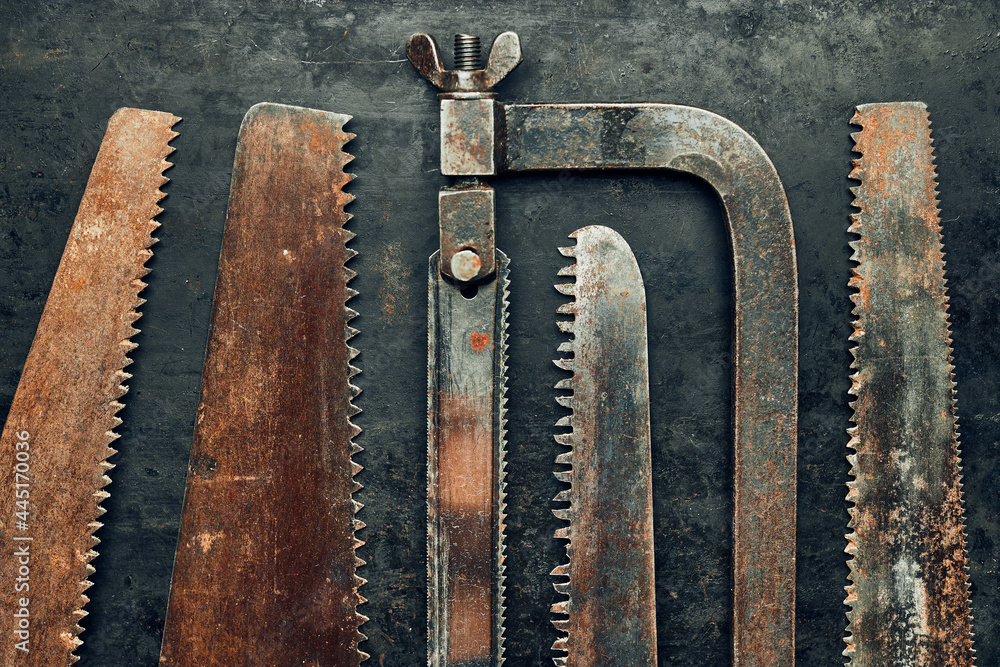 Saws on metal surface. Rusty tools for maintenance. Hardware to fix. Technical background Saws on metal surface. Rusty tools for maintenance. Hardware to fix. Technical background