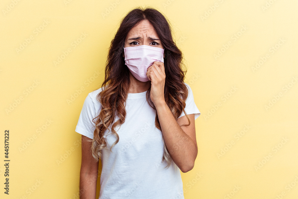 Young mixed race woman wearing a protection for virus isolated on yellow background biting fingernails, nervous and very anxious. Young mixed race woman wearing a protection for virus isolated on yellow background biting fingernails, nervous and very anxious.