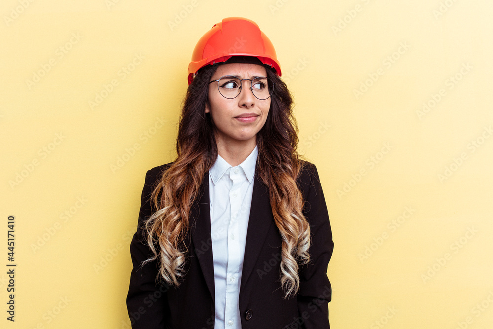 Young architect mixed race woman isolated on yellow background confused, feels doubtful and unsure. Young architect mixed race woman isolated on yellow background confused, feels doubtful and unsure.