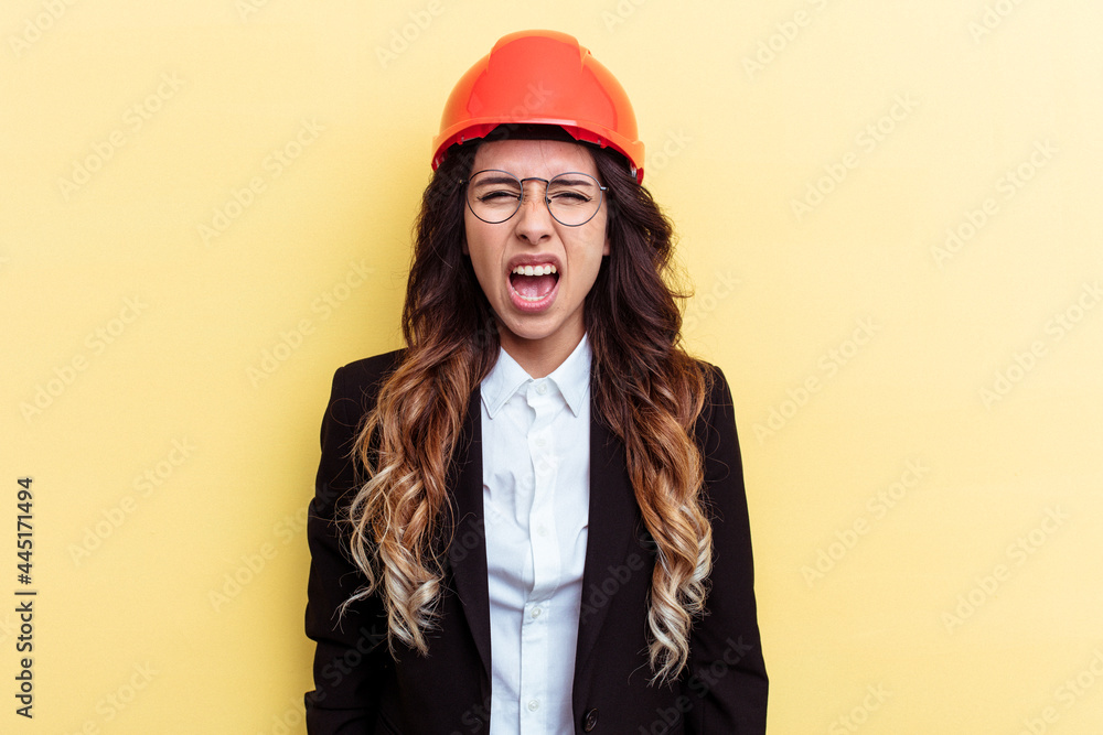 Young architect mixed race woman isolated on yellow background screaming very angry and aggressive. Young architect mixed race woman isolated on yellow background screaming very angry and aggressive.