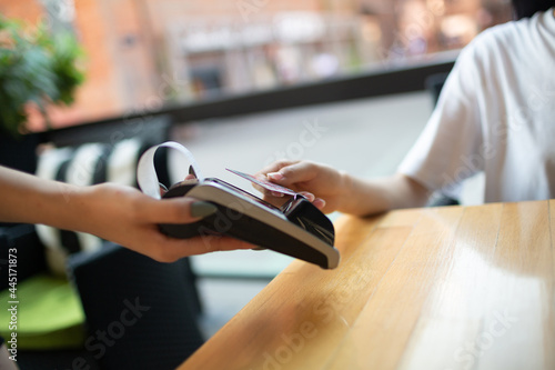 Fotografie Close up hand of Woman pay with credit card contactless payment terminal cashier in outdoor cafe