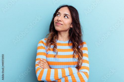 Young mexican woman isolated on blue background dreaming of achieving goals and purposes