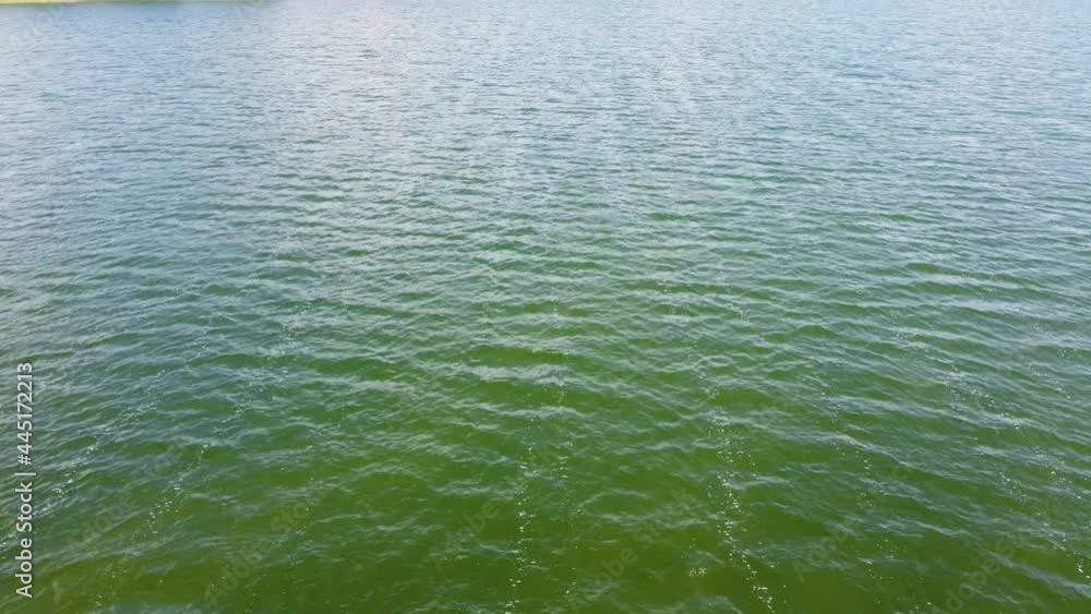 Close-up of a drone shot over green smooth water surface Close-up of a drone shot over green smooth water surface