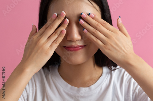 Close up portrait of young asian woman with hand palms fingers nails manicure closed eyes face