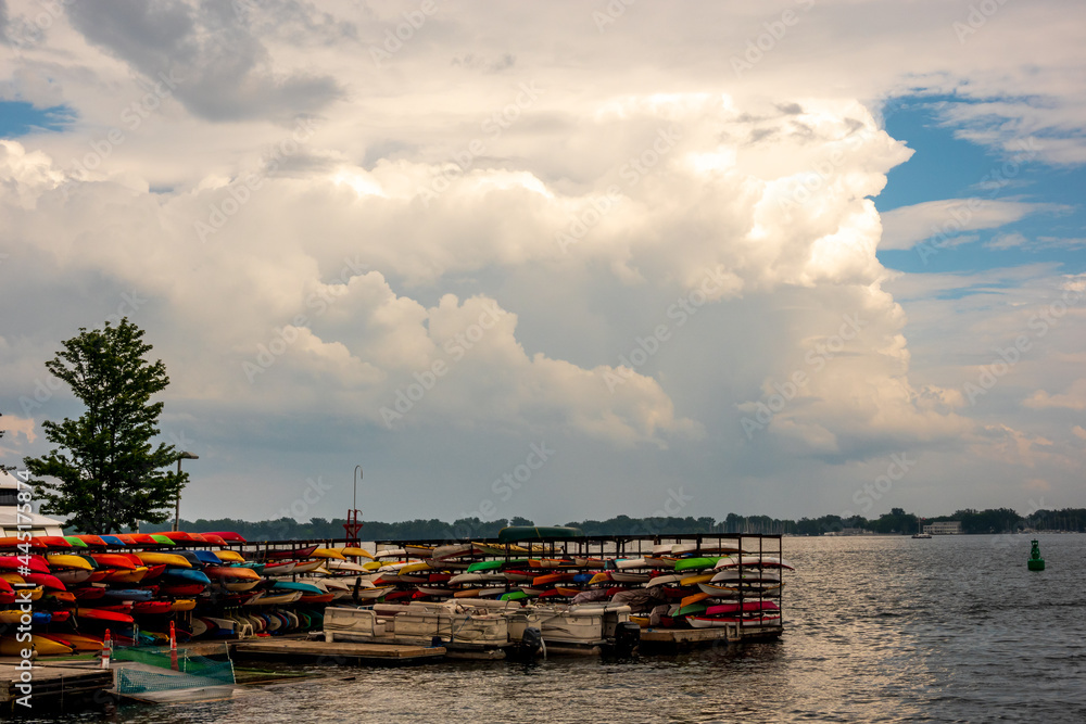 Boats of different types at a slip on a harbour in summer time with large dreamy clouds behind them. Banner