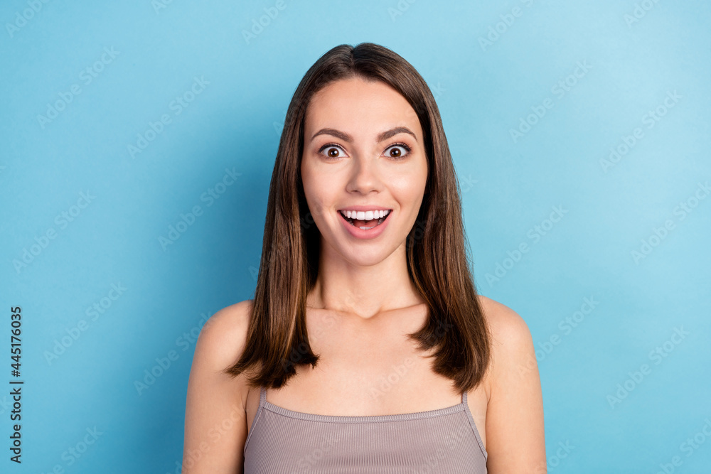 Photo of impressed funky young lady wear grey top big eyes open mouth smiling isolated blue color background Photo of impressed funky young lady wear grey top big eyes open mouth smiling isolated blue color background
