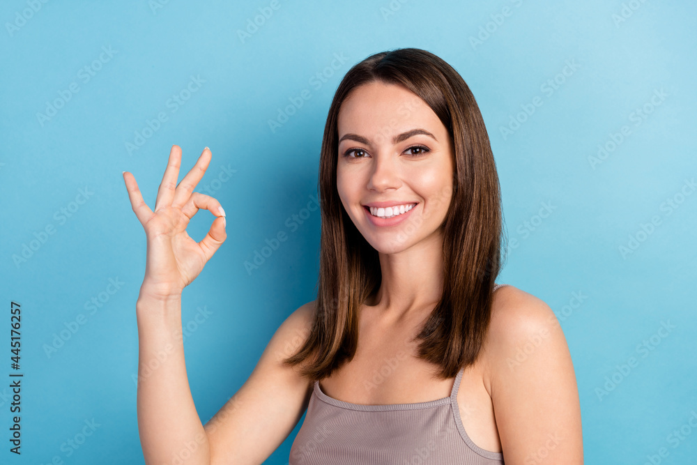 Portrait of attractive cheerful girl showing ok-sign ad perfect solution isolated over bright blue color background Portrait of attractive cheerful girl showing ok-sign ad perfect solution isolated over bright blue color background