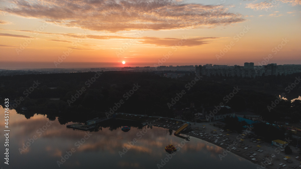 Scenic dark aerial sunrise with clouds reflecting in mirror water on river. Early morning, dawn in Kharkiv Zhuravlivskyy Hidropark from sky. Drone photography
