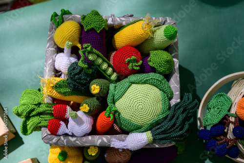 High resolution photo knitted toys - vegetables lie outdoors