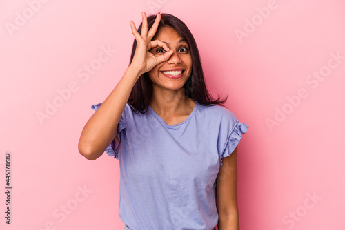 Young latin woman isolated on pink background excited keeping ok gesture on eye.