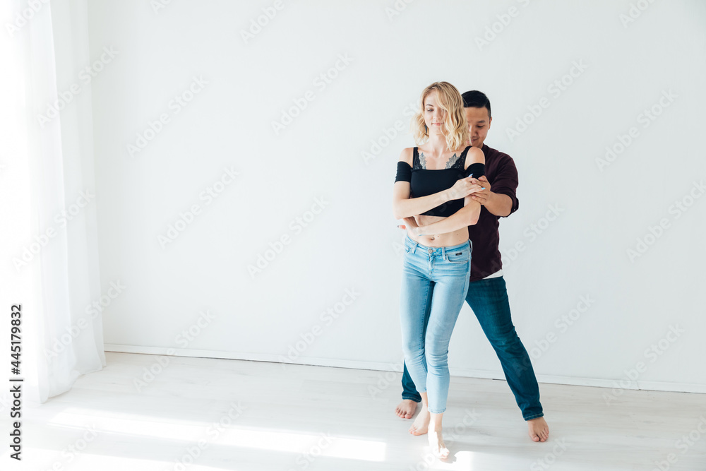 beautiful man and woman dancing together to music in a white room beautiful man and woman dancing together to music in a white room