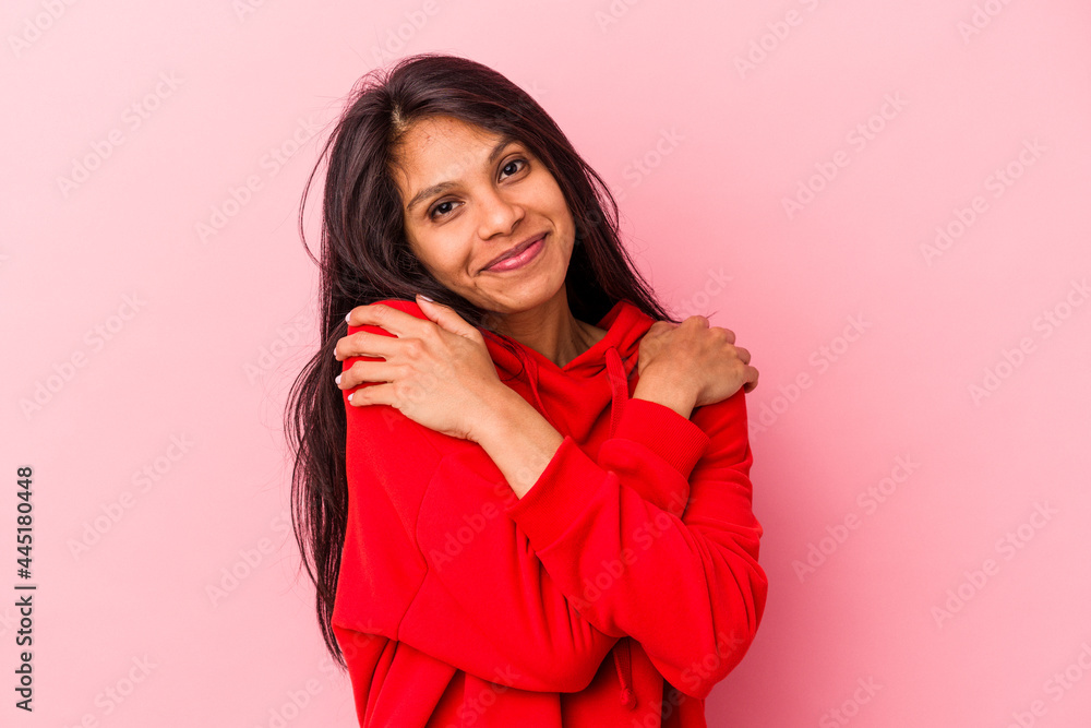 Young latin woman isolated on pink background hugs, smiling carefree and happy. Young latin woman isolated on pink background hugs, smiling carefree and happy.