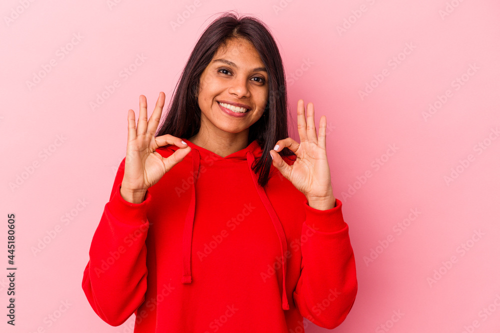 Young latin woman isolated on pink background cheerful and confident showing ok gesture. Young latin woman isolated on pink background cheerful and confident showing ok gesture.
