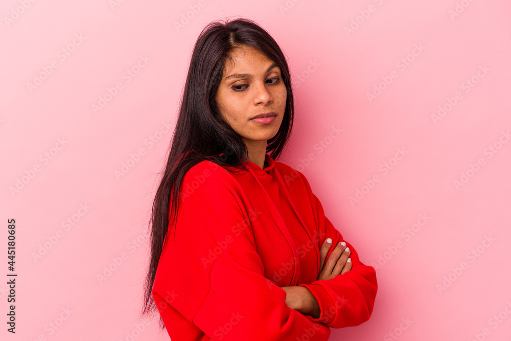 Young latin woman isolated on pink background suspicious, uncertain, examining you. Young latin woman isolated on pink background suspicious, uncertain, examining you.
