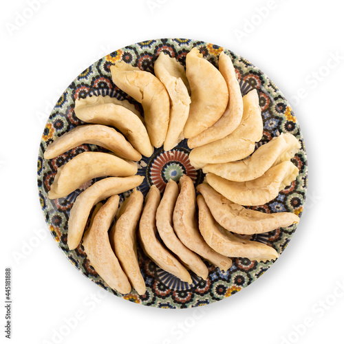 Traditional Moroccan handmade cookies on a plate, isolated on white.
