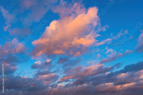 Blue sky background. Blue sky with pink clouds. Natural texture. A pattern with a clear daylight sky. Summer clouds bottom view. Background natural. Texture with blue firmament.