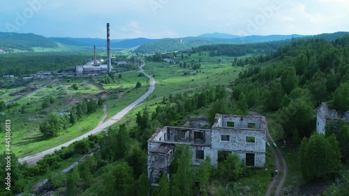 abandoned buildings of the old mine behind the village and a view of the stokehouse with chimneys. a beautiful place in nature in the village. Tuimsky failure in Khakassia. Tuim, Russia. depressing photo