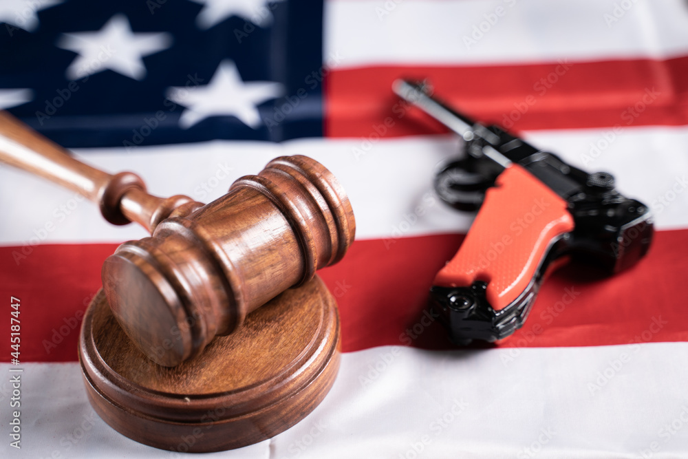 Concept showing of US or American gun laws with Judge gavel and Vintage Pistol on American flag.