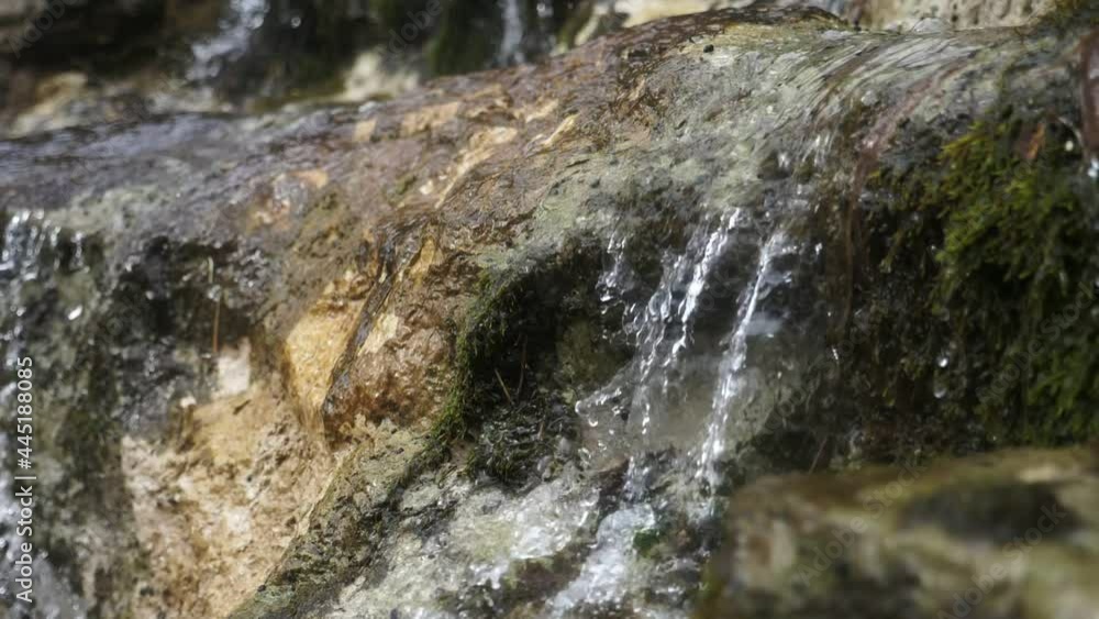 Mountain brook with waterfall flows among rocks in a magic forest in summer Mountain brook with waterfall flows among rocks in a magic forest in summer