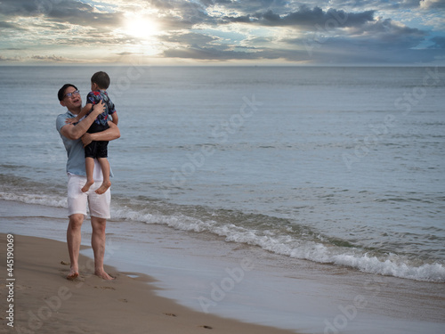 Happy time, father and son playing together at the beach. Concept of friendly family..