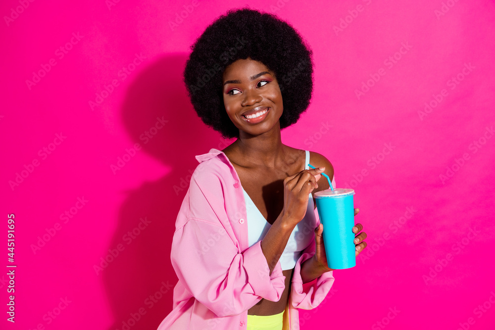 Photo of charming pretty dark skin lady wear casual shirt drinking soda looking empty space smiling isolated pink color background Photo of charming pretty dark skin lady wear casual shirt drinking soda looking empty space smiling isolated pink color background