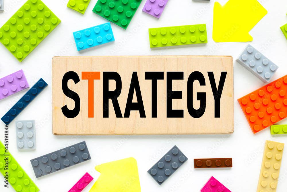 STRATEGY. text on a wooden plate near the constructor of different colors STRATEGY. text on a wooden plate near the constructor of different colors