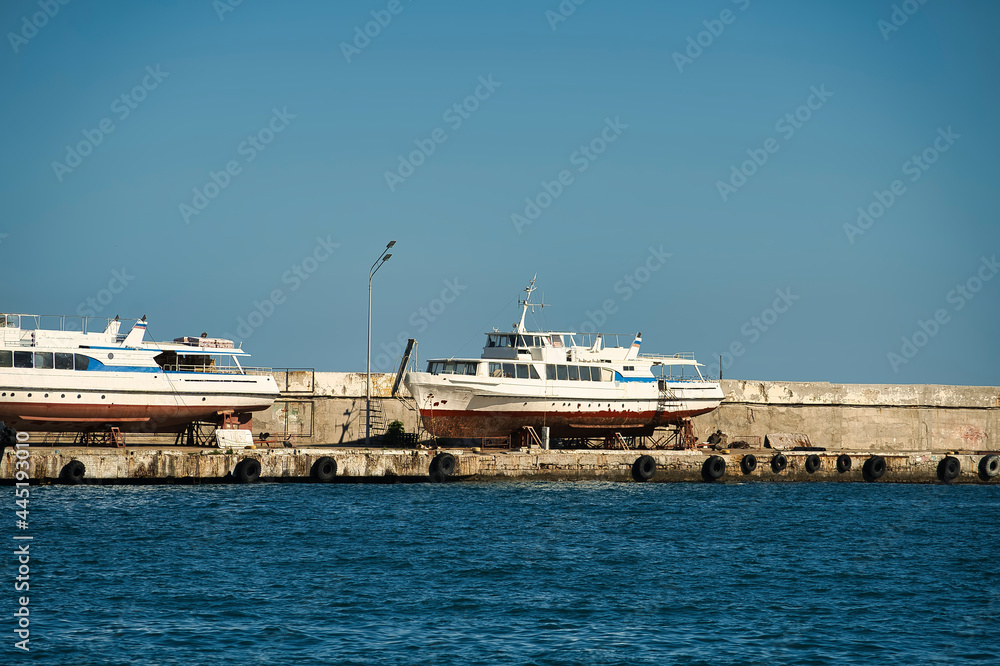 Seascape with a pier in Yalta and old boats in the parking lot Seascape with a pier in Yalta and old boats in the parking lot