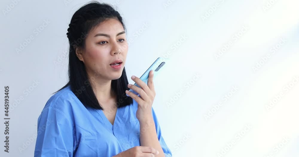 Portrait of young asian nurse talking by cell phone in clinic Portrait of young asian nurse talking by cell phone in clinic