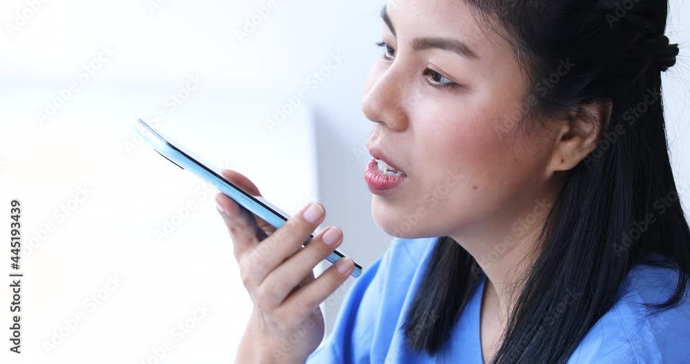 Portrait of young asian nurse talking by cell phone in clinic Portrait of young asian nurse talking by cell phone in clinic