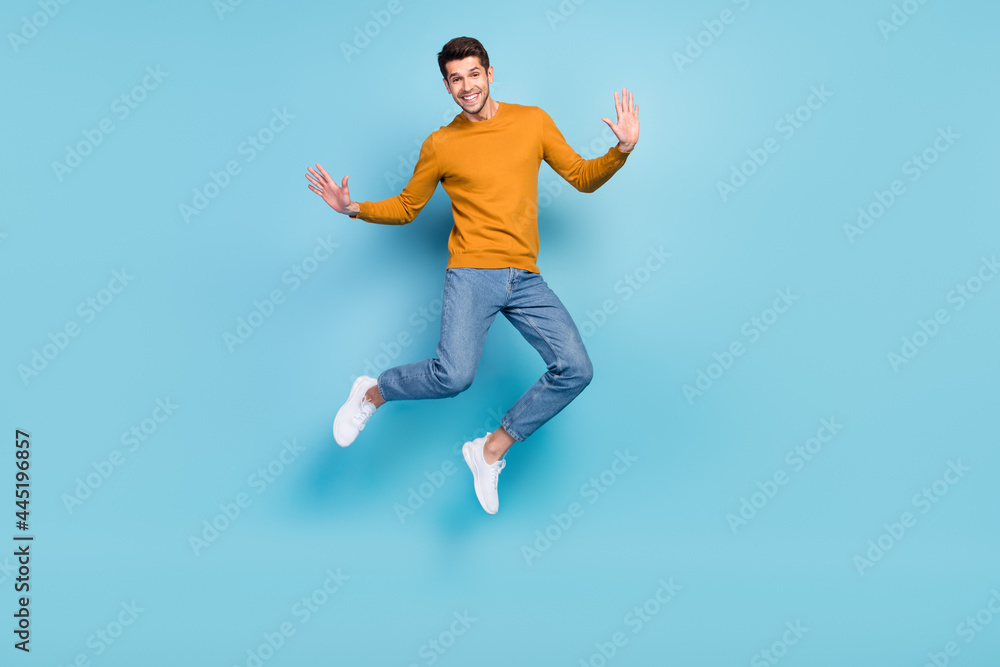 Full length body size view of attractive cheerful funny guy jumping good mood isolated over bright blue color background Full length body size view of attractive cheerful funny guy jumping good mood isolated over bright blue color background