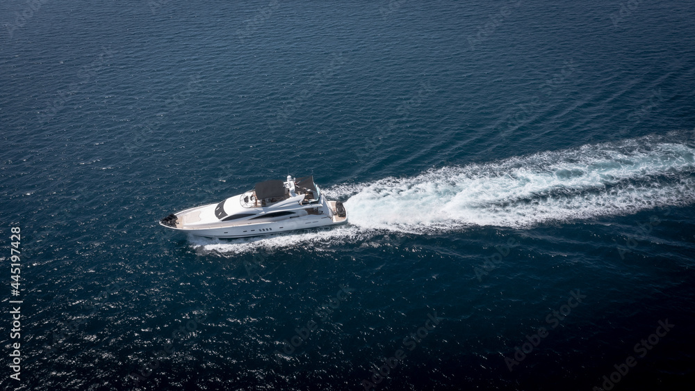 Aerial view of luxury speedboat yacht cruising in deep ocean water. Aerial view of luxury speedboat yacht cruising in deep ocean water.
