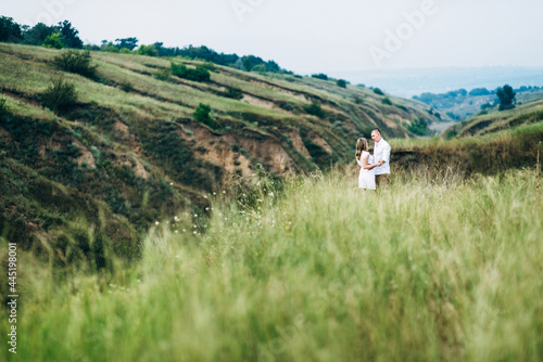 Canvas Print a guy with a girl in light clothes on the background of a green canyon
