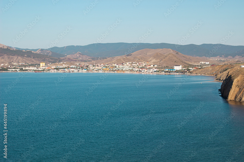 A resort town in the Crimea on the Black Sea coast. Koktebel from a bird's-eye view on the background of mountains