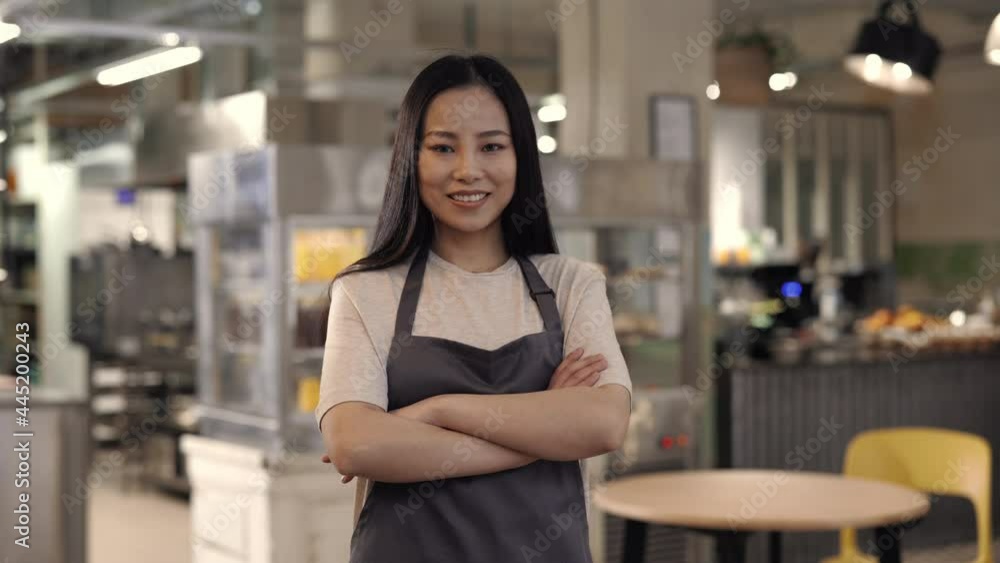 Confident asian woman in apron posing at own cafe Confident asian woman in apron posing at own cafe