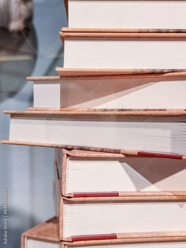 Fototapeta premium High books stack isolated on blurred background.forefront of a group of books stacked.Old books on shelf in the Library