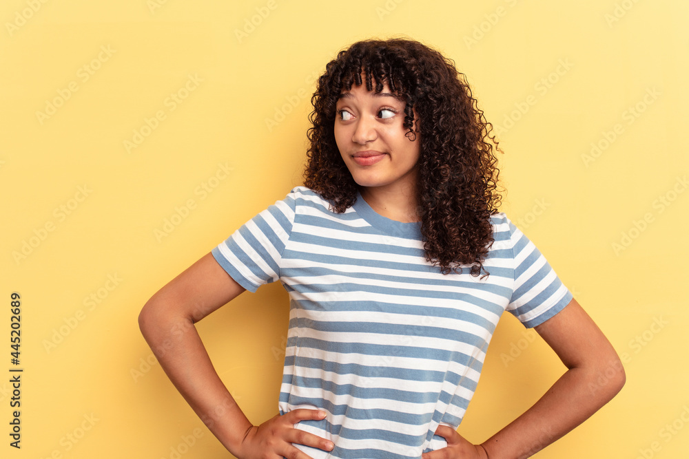 Young mixed race woman isolated on yellow background confused, feels doubtful and unsure. Young mixed race woman isolated on yellow background confused, feels doubtful and unsure.