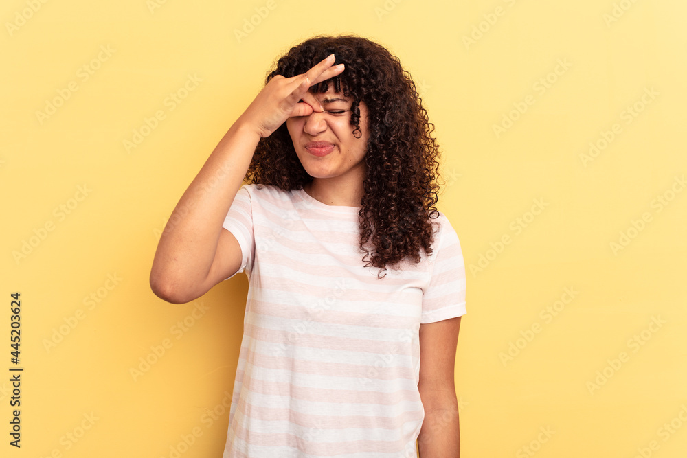 Young mixed race woman isolated on yellow background having a head ache, touching front of the face. Young mixed race woman isolated on yellow background having a head ache, touching front of the face.
