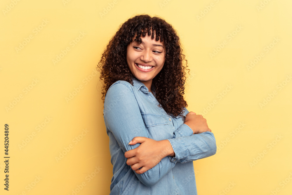 Fototapeta premium Young mixed race woman isolated on yellow background laughing and having fun.