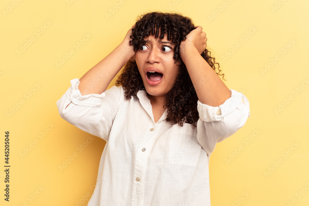 Young mixed race woman isolated on yellow background screaming, very excited, passionate, satisfied with something. Young mixed race woman isolated on yellow background screaming, very excited, passionate, satisfied with something.