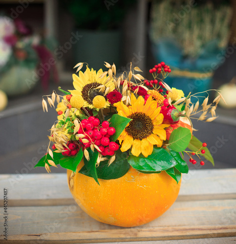 Floral bouquet in a pumpkin vase. Autumn pumpkin flower arrangement. Halloween Selective focus
