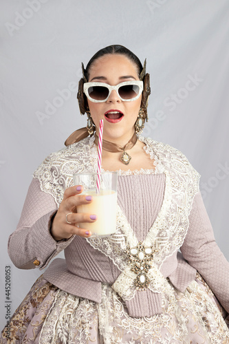 young girl dressed as fallera caught drinking horchata photo