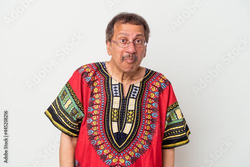 Senior indian man wearing a Indian costume isolated on white background shrugs shoulders and open eyes confused.