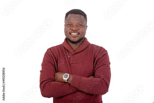 happy young man crossing his arms smiling.