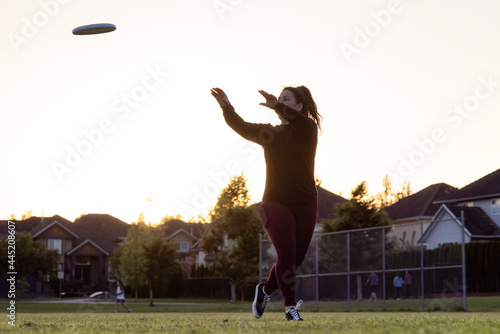 Slika na platnu White Caucasian Adult Woman Playing Ultimate Frisbee in the Green Field at neighborhood city park