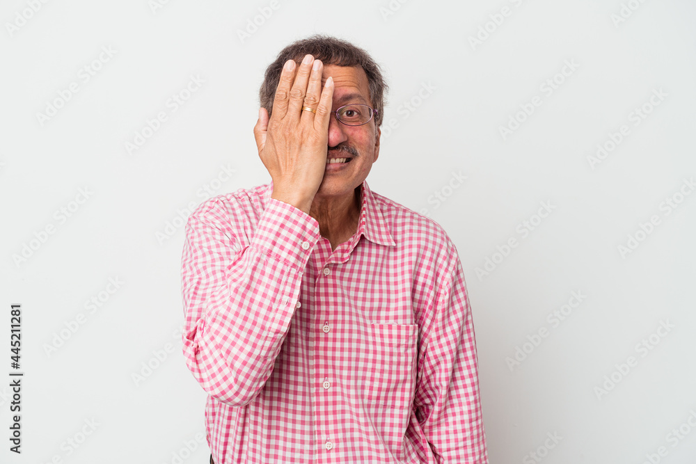 Middle aged indian man isolated on white background having fun covering half of face with palm. Middle aged indian man isolated on white background having fun covering half of face with palm.