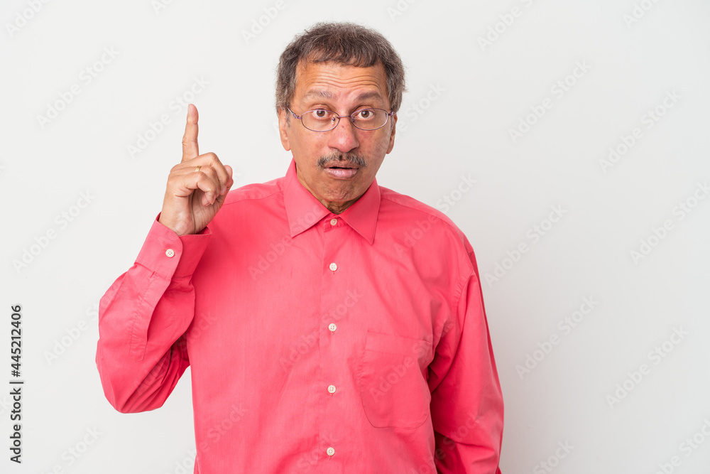 Middle aged indian man isolated on white background pointing upside with opened mouth.