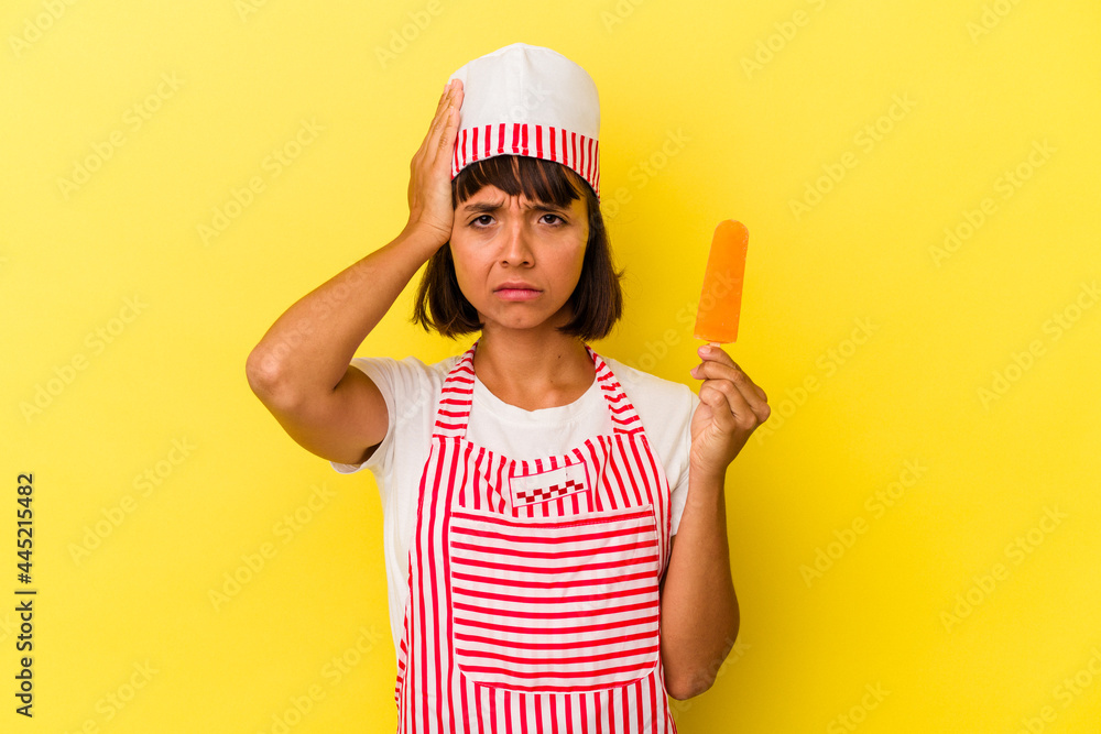 Young mixed race ice cream maker woman holding an ice cream isolated on yellow background being shocked, she has remembered important meeting. Young mixed race ice cream maker woman holding an ice cream isolated on yellow background being shocked, she has remembered important meeting.
