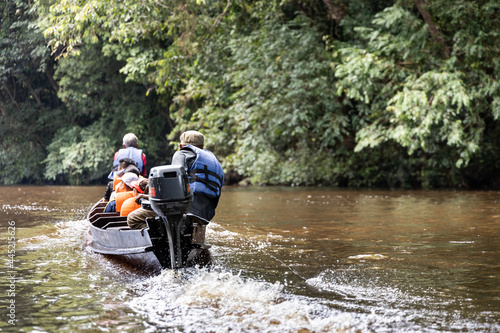 River cruise along scenic Tahan River with lush rainforest foliage at Taman Negara National Park, Pahang