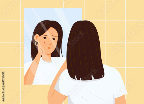 Girl looking in a bathroom mirror. Problem face skin with acne