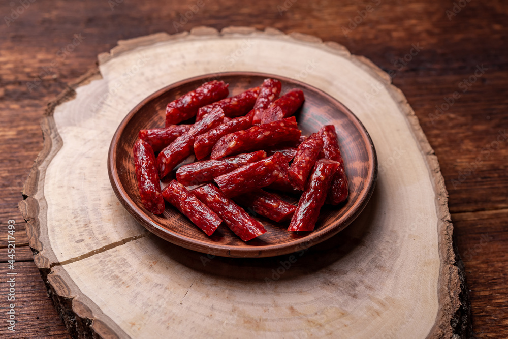 Dried smoked sausages on a wooden background. Beer snack. Dried smoked sausages on a wooden background. Beer snack.